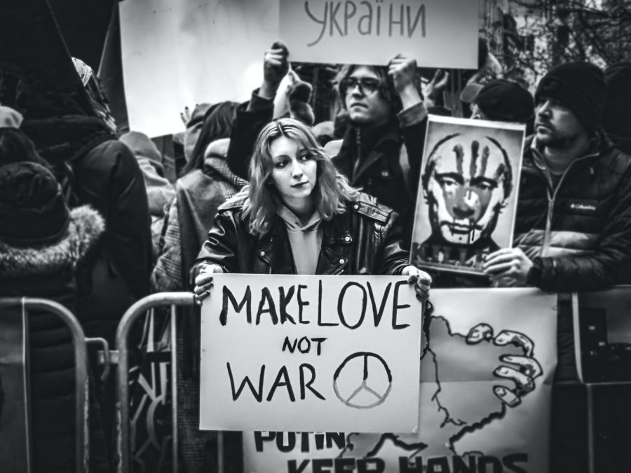 Woman+holding+sign+saying+Make+Love+Not+War+in+New+York%2C+USA